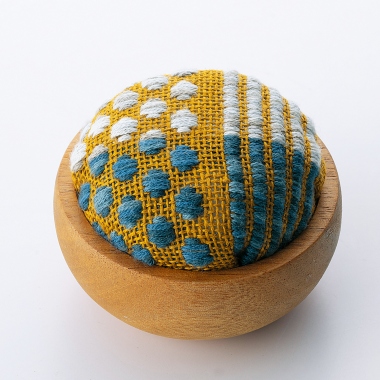Pin cushion with wooden bowl.
