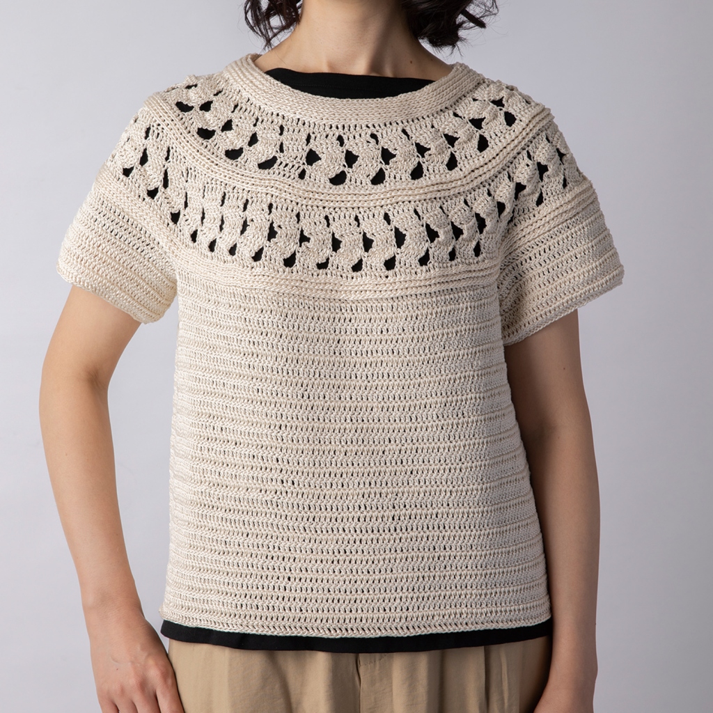 メリハリをつけて、長編みと引き上げ編みで構成された個性的な透かし模様で編み上げた丸ヨークのプル