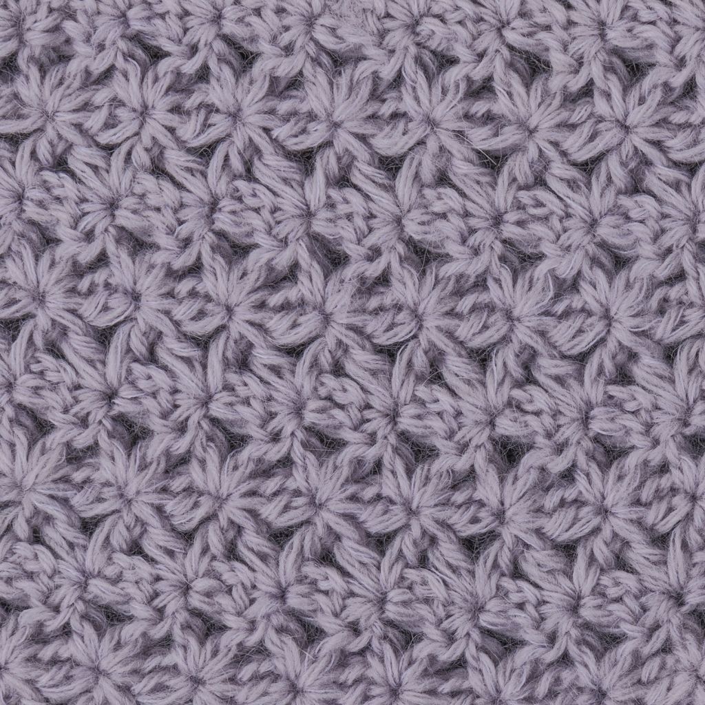 全体を麻の葉模様で編んだマフラーは斜めに編み、変化をつけた編み地