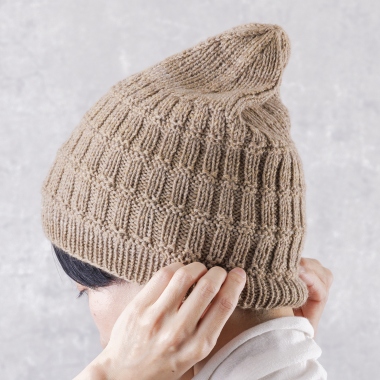 優しく頭を包み込むように、2種類のゴム編みで編み上げたルーズな帽子